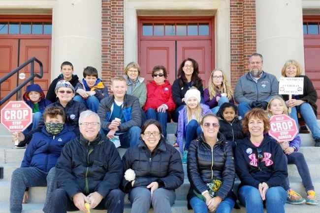 A group of CROP walk participants sitting on the front steps of the church