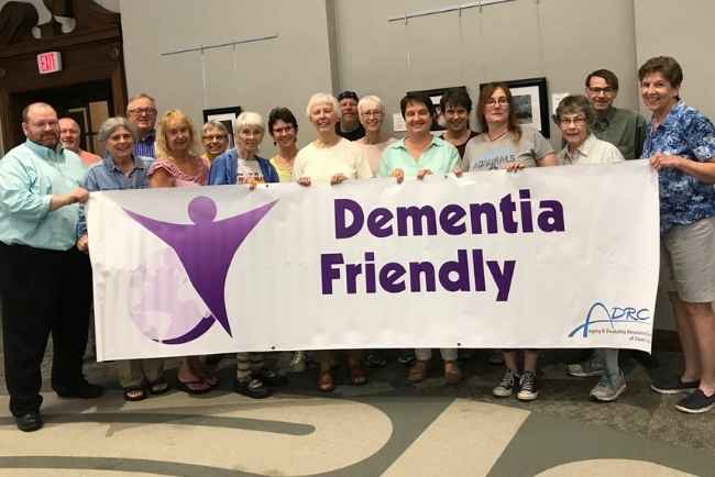 People holding a "dementia friendly" banner