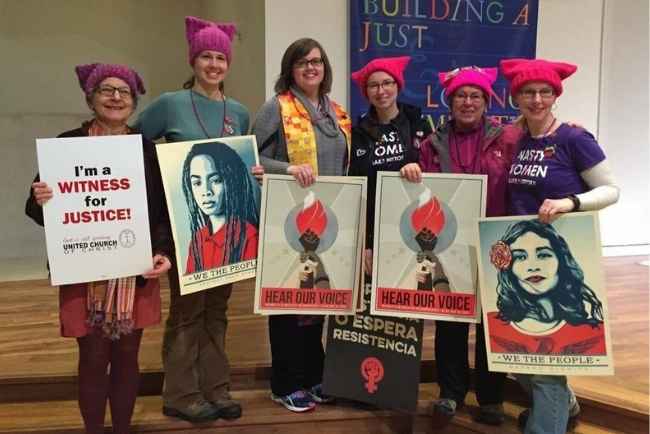 Six people holding posters promoting social justice